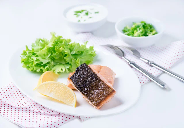 Grilled red fish fillet with lemon and green salad